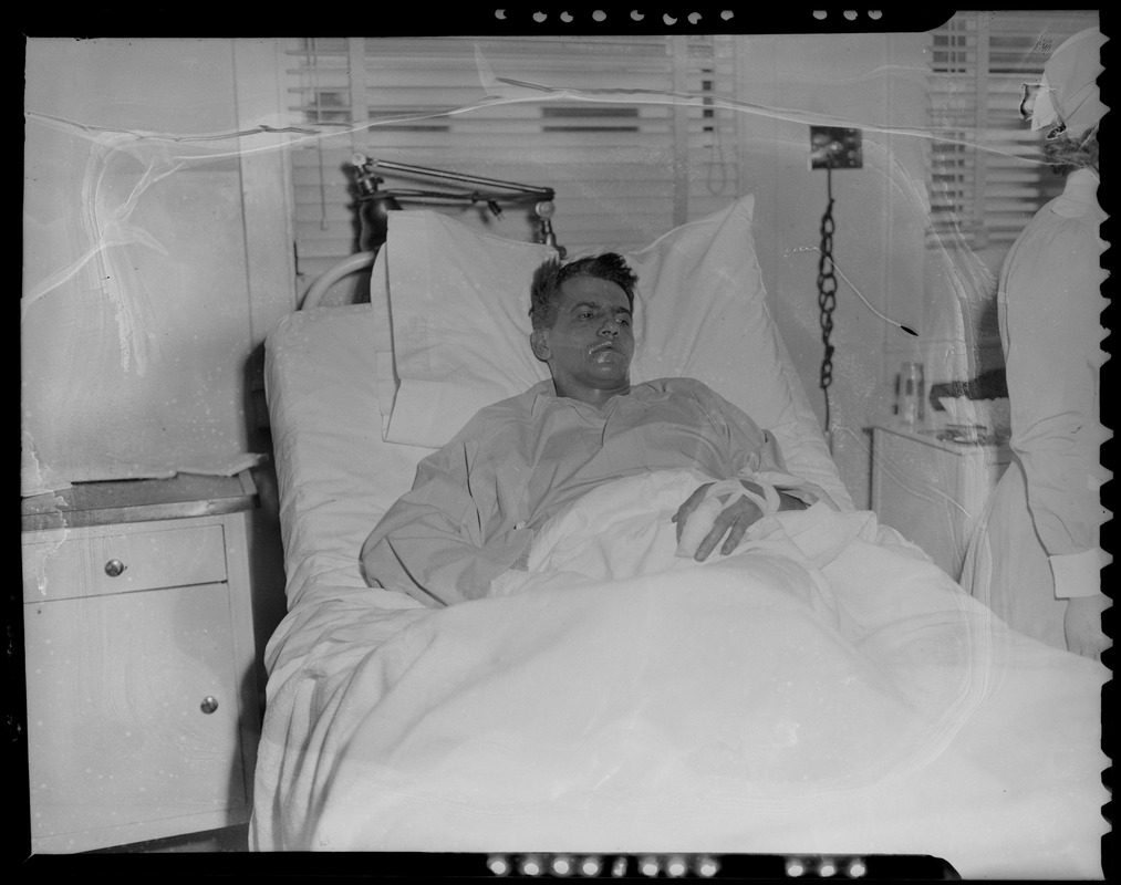 An injured person lying in a hospital bed, likely military personnel injured in the U.S.S. Bennington aircraft carrier explosion off coast of Rhode Island