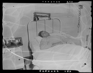 An injured person lying in a hospital bed, likely military personnel injured in the U.S.S. Bennington aircraft carrier explosion off coast of Rhode Island