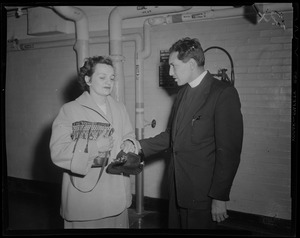 A chaplain speaking with a woman, possibly a relative of military personnel injured in the U.S.S. Bennington aircraft carrier explosion off coast of Rhode Island