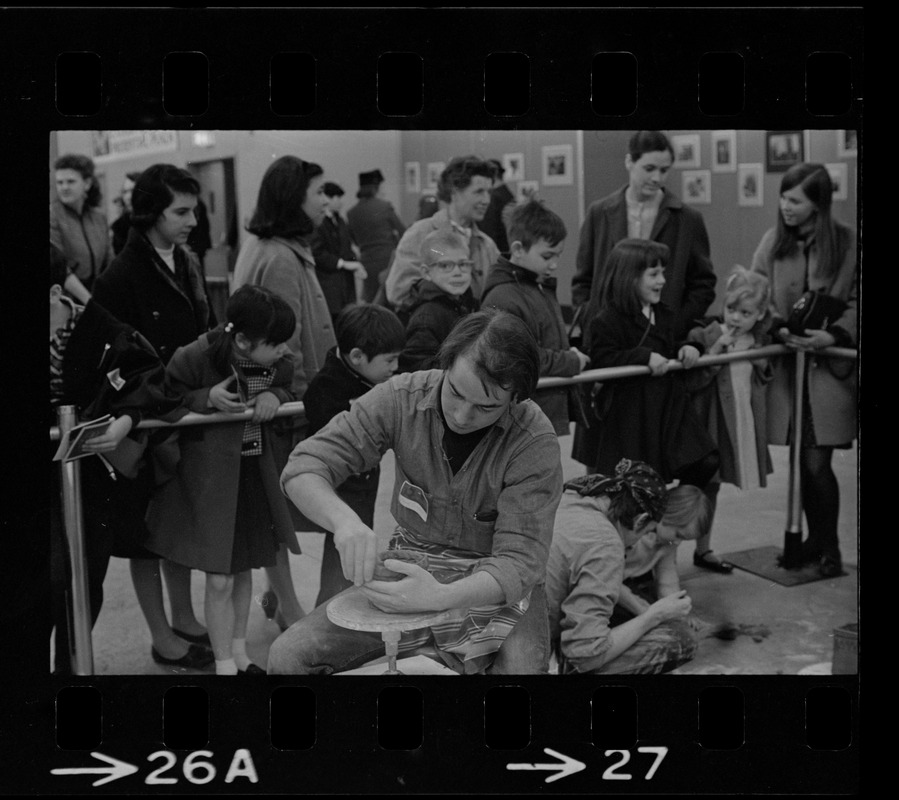 Man making a clay pot while crowd watches at Winterfest