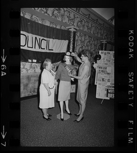 An unidentified woman and Mrs. Bruce Benson prepare a mannequin at League of Women Voters convention