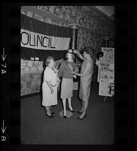 An unidentified woman and Mrs. Bruce Benson prepare a mannequin at League of Women Voters convention