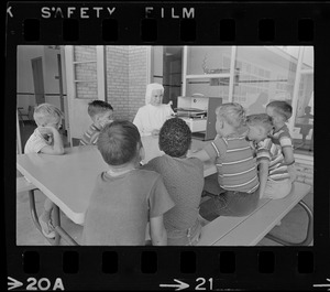 Children listening to record player with nun