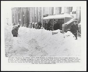 New York - Attack City's Snow - Workmen in Bowling Green area of lower Manhattan use shovels to clear Broadway sidewalks of snow this morning after 12-inch overnight fall - the heaviest in seven years - virtually paralyzed traffic. Autos and trucks were unable to make headway through the streets, trains ran far behind schedules and even some subway runs were curtailed.