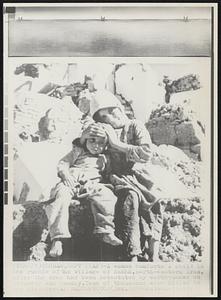 A woman comforts a child in the rubble of the village of Kakhk, north-eastern Iran, after the area had been devastated by earthquakes on Saturday and Sunday. Tens of thousands were killed in the disaster.