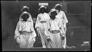 Five women wearing matching hats and costumes