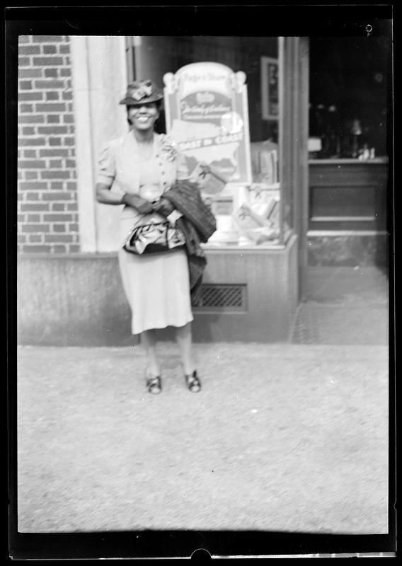 A woman stands in front of a shop window