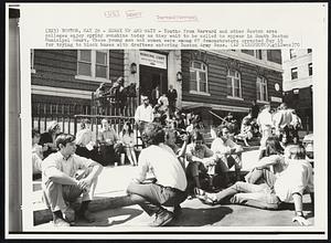Hurry Up And Wait - Youths from Harvard and other Boston area colleges enjoy spring sunshine today as they wait to be called to appear in South Boston Municipal Court. These young men and women were among 67 demonstrators arrested May 15 for trying to block buses with draftees entering Boston Army Base.