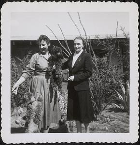 Olga Koussevitzky standing with an unidentified woman holding a dog