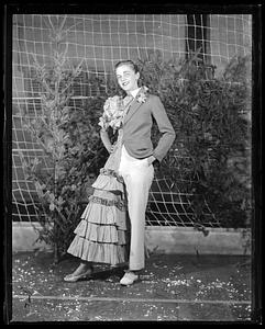 A person wearing a piece of clothing that is half a suit, half a dress