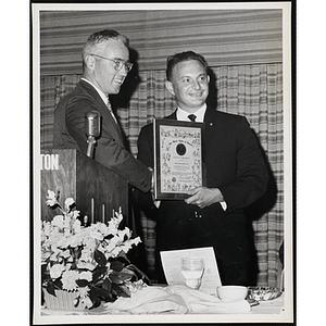 Thomas E. Leggat, at left, presenting a certificate of appreciation to Les Oshry, president of the Kiwanis Club of Boston