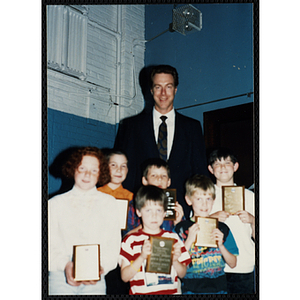 Former Boston Celtic Dave Cowens posing for a group picture with six boys and girls at a Kiwanis Awards Night