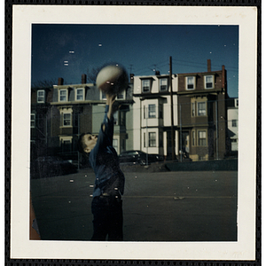 A boy shooting a basketball in the South Boston Boys' Club playground
