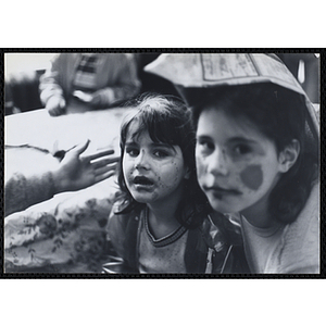 Two girls model face paint at a carnival