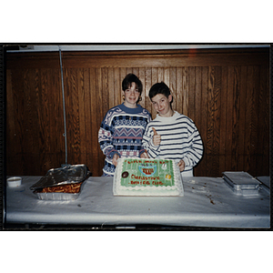 A girl and a boy pose with a Super Bowl XXVII cake