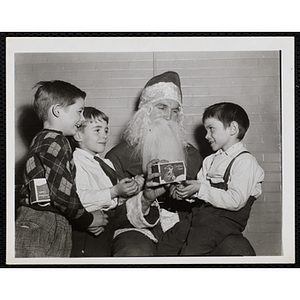 Three boys pose with Santa Claus