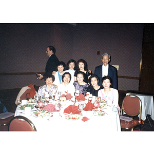 Chinese Progressive Association members pose around a dinner table