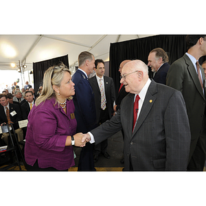 Dr. George J. Kostas shakes hands with Suzanne Feeley, the Assistant Director of Events at Northeastern, during the groundbreaking ceremony
