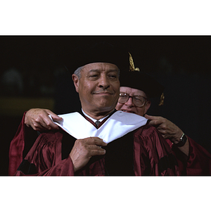 Honorary degree recipient receives hood at commencement ceremony