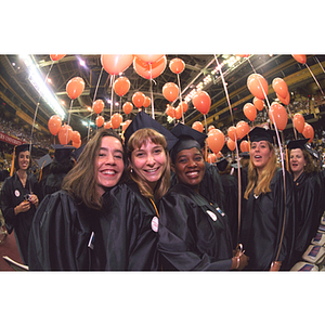 Graduates holding balloons during commencement ceremony