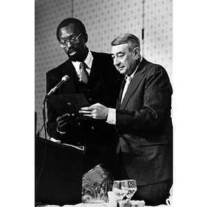 Thomas Sanders and Howard Cosell at a podium