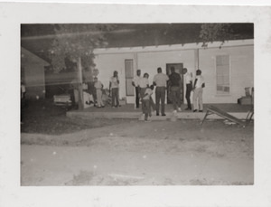 Group gathered at might on the porch of Rust Avenue house rented by the Congress of Federated Organizations (COFO)
