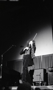 Unidentified band in performance in what appears to be a high school gymnasium: violinist