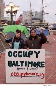 Occupy Baltimore: two demonstrators flashing the peace sign and posing behind 'Occupy Baltimore' sign