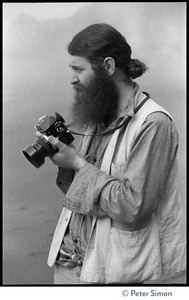 Rameshwar Das: half-length portrait with camera on the beach