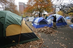 James Vecchione rakes leaves around the tents in Occupy Providence