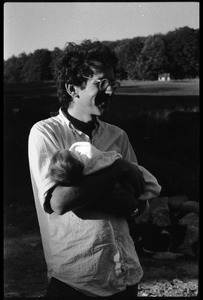 Dan Keller holding an infant, Montague Farm Commune