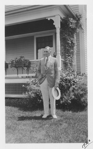 Unidentified male member of the class of 1905 standing outside in front of a house