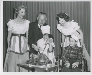 Abe Stark and two performers carving turkey with young clients