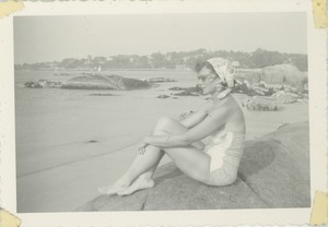 Bernice Kahn seated on a rock overlooking a harbor