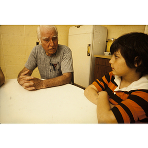 Man talking to a child at a kitchen table