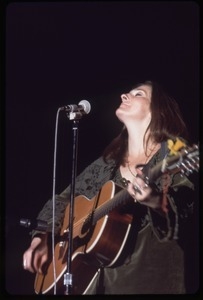 Judy Collins: in green velvet dress with guitar, performing on stage