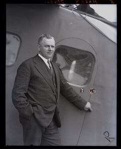 Harry Jones, pilot, standing next to his plane