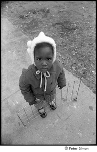 Young girl holding metal grate
