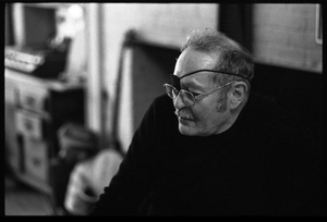 W. Eugene Smith, seated at a desk in his home