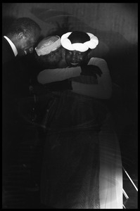 Dancer hugging Emma Berdis Jones Baldwin (James Baldwin's mother) with James Baldwin nearby, at James Baldwin's birthday celebration