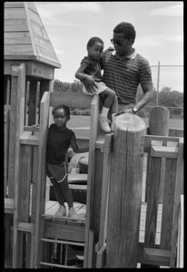 Rory McClaurin with children atop playground equipment
