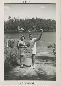 Bernice and David Kahn waving from a lake shore