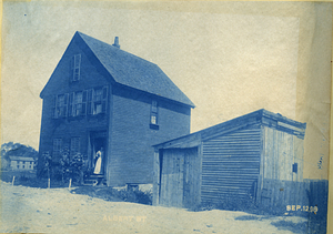 [Man and woman with dog in front of house on Albert Street]