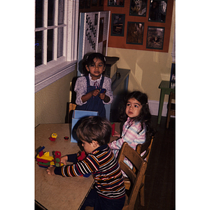 Young children sitting at a table playing with toys