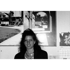 Portrait of a woman standing in front of a large photograph of Villa Victoria.