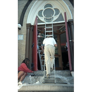 Volunteers painting the doors and entryway of the Jorge Hernandez Cultural Center.