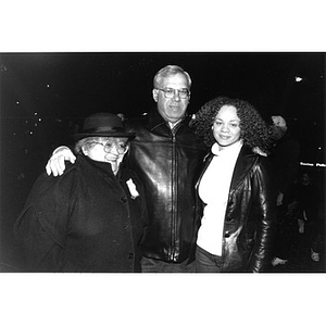 Mayor Menino poses with his arms around the shoulders of two women.