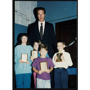 Former Boston Celtic Dave Cowens posing for a group picture with four boys and girls at a Kiwanis Awards Night