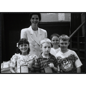 Heather Khan, a former news anchor, posing with four boys and girls holding their awards at a Kiwanis Awards Night