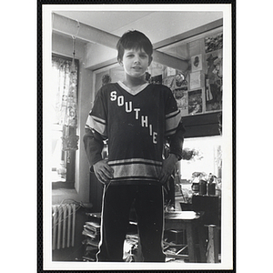 A boy posing in a sports jersey with the text "SOUTHIE" on it at the South Boston Boys & Girls Club